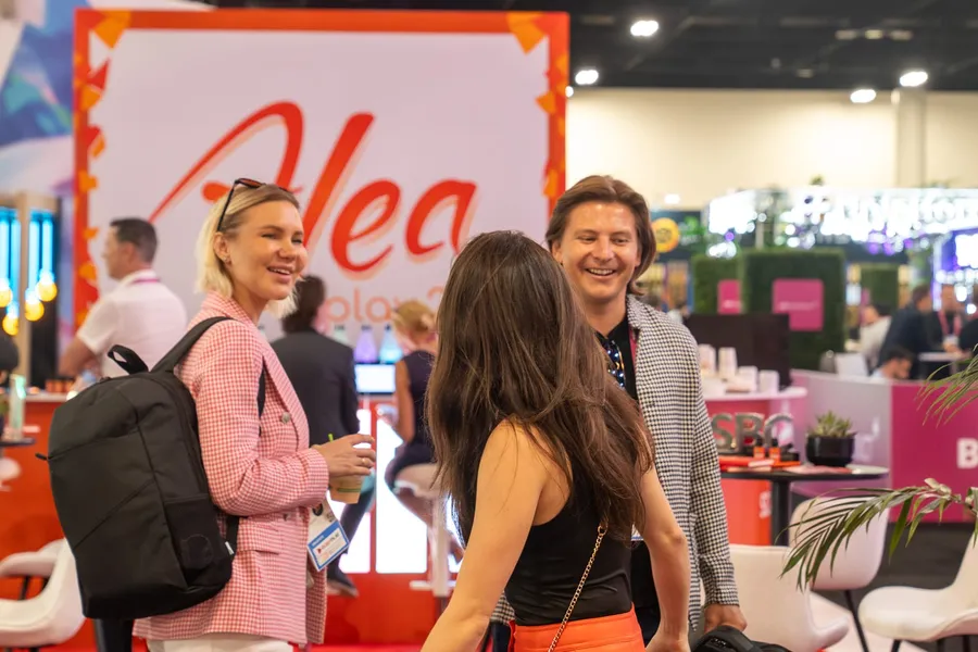 Attendees sharing a laugh at the ALEA booth during SBC Summit Americas in Fort Lauderdale