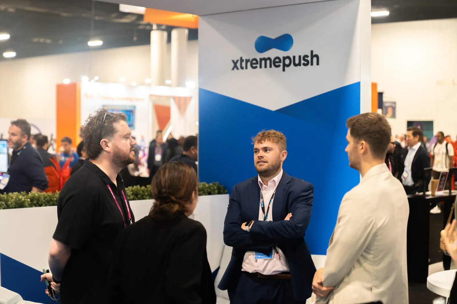 Business conversation in front of the Xtremepush booth on a busy convention floor in Fort Lauderdale
