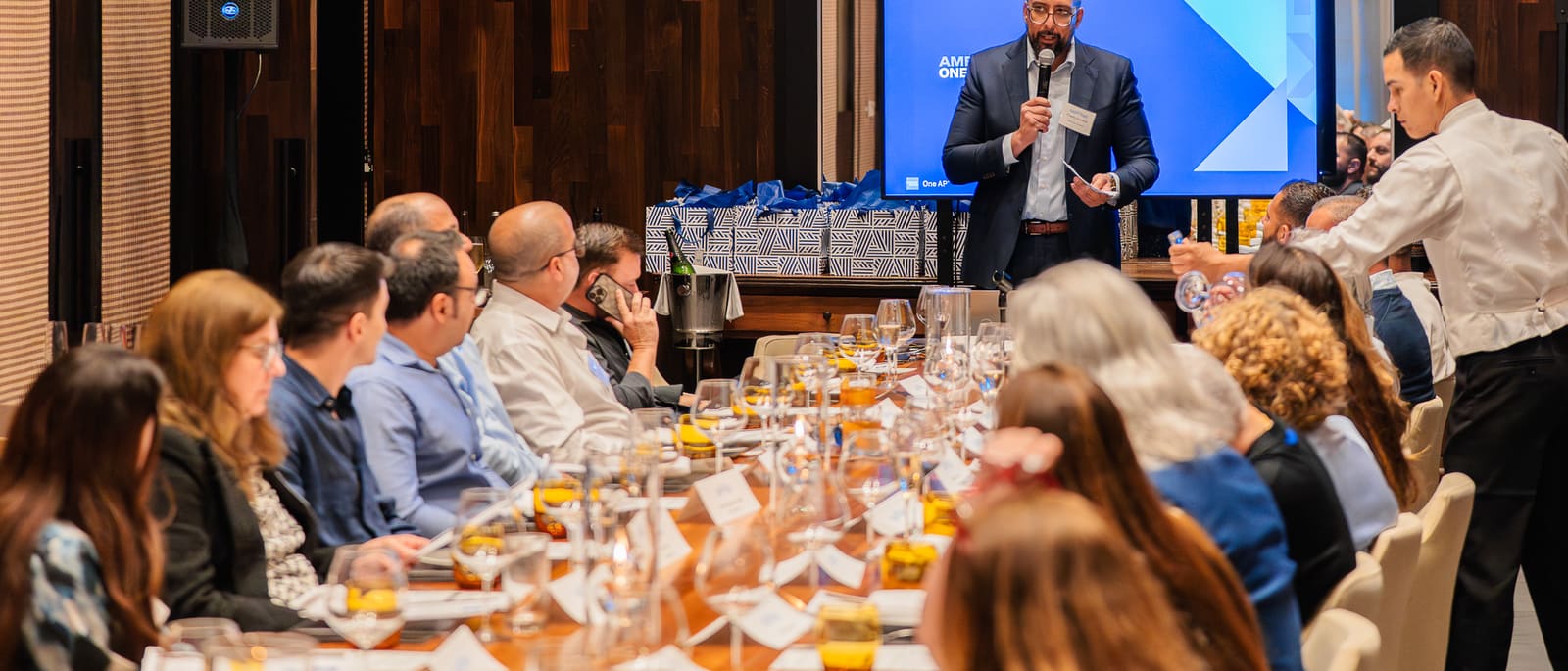 Speaker presenting at an American Express dinner photographed by Lunna Agency